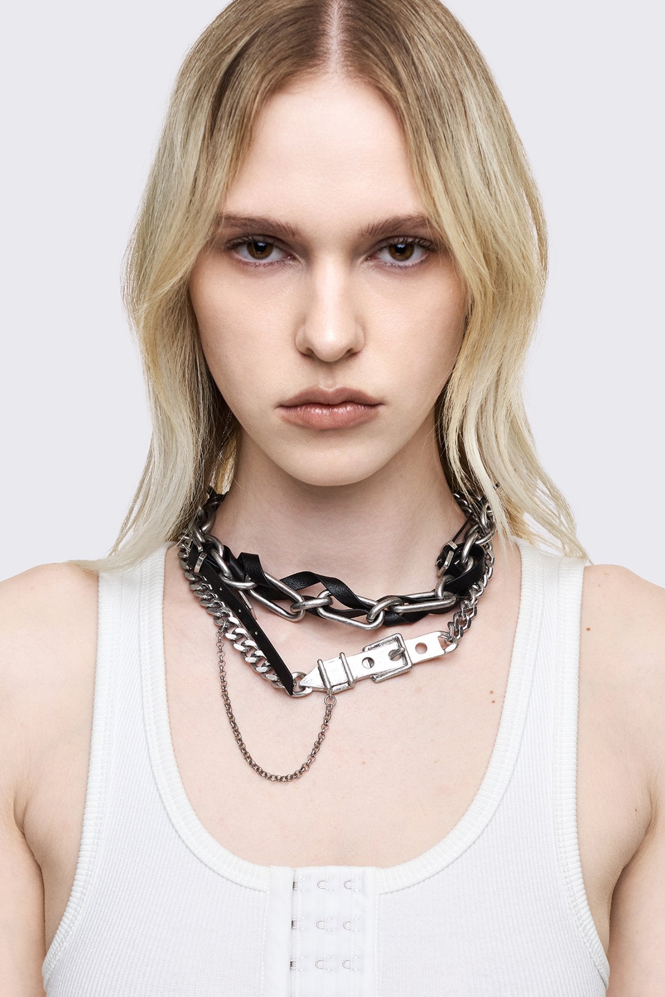 Silver-tone layered chain necklace with chunky links, black faux leather weave, draped curb chain and buckle detail.