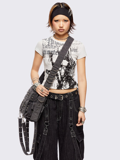 Grey washed denim crossbody bag with all over straps, studs and silver hardware details.