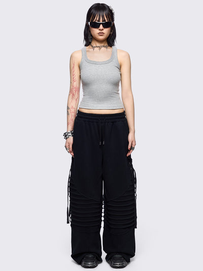 Black wide leg sweatpants featuring moto pintuck panels and lace-up details. 