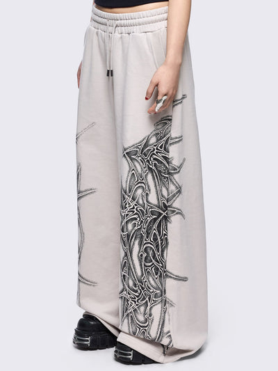 Grey wide leg sweatpants featuring a black sigilism graphic side print.