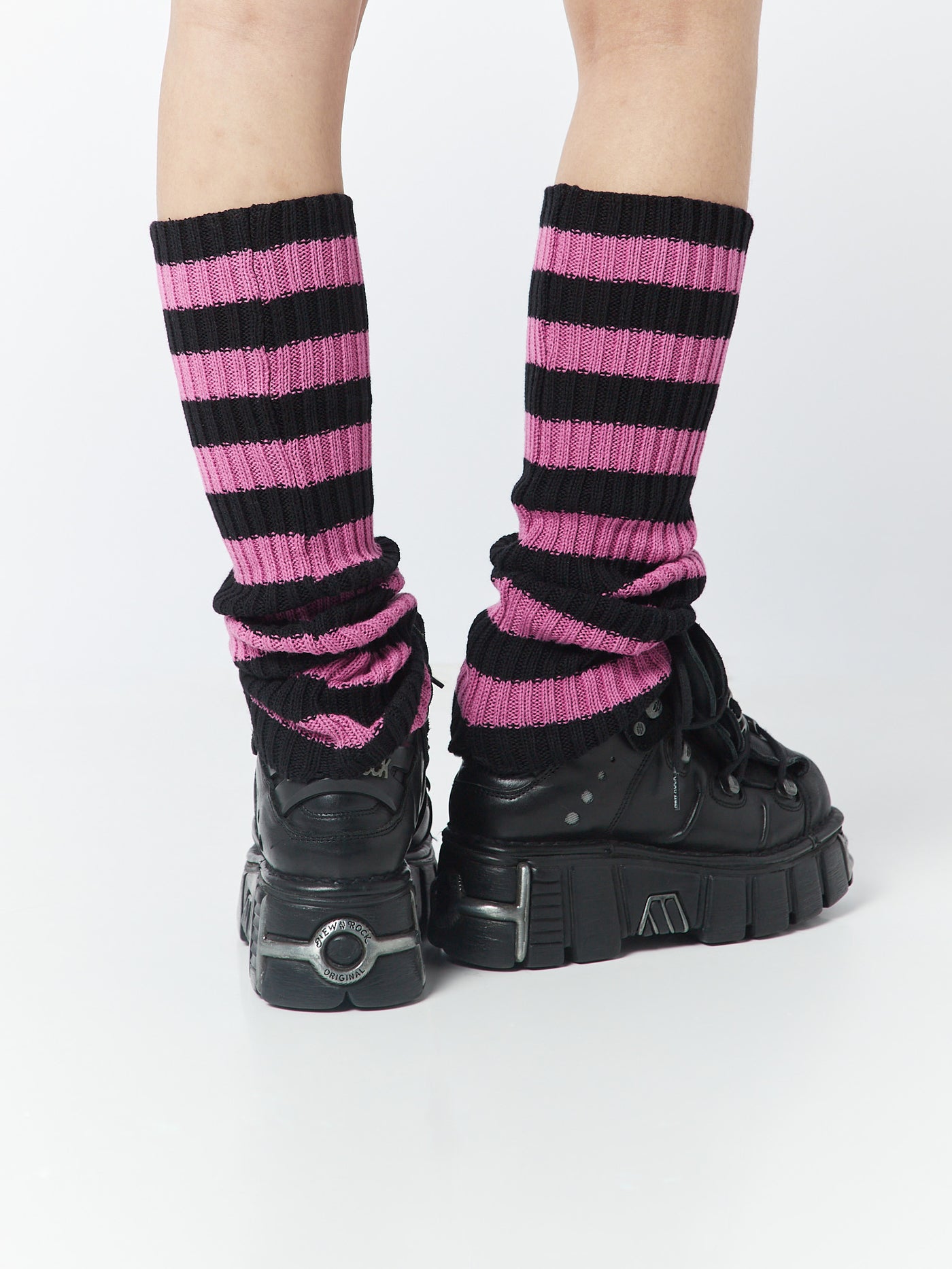 Pink and black striped leg warmers by Minga London, adding a vibrant and stylish pop of color to your outfit while keeping your legs warm and cozy.