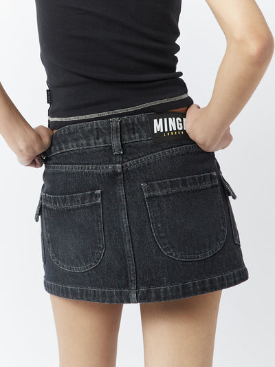 A washed black mini cargo skirt named Ashley by Minga London. This skirt features cargo-style pockets and offers a versatile and edgy addition to your wardrobe.