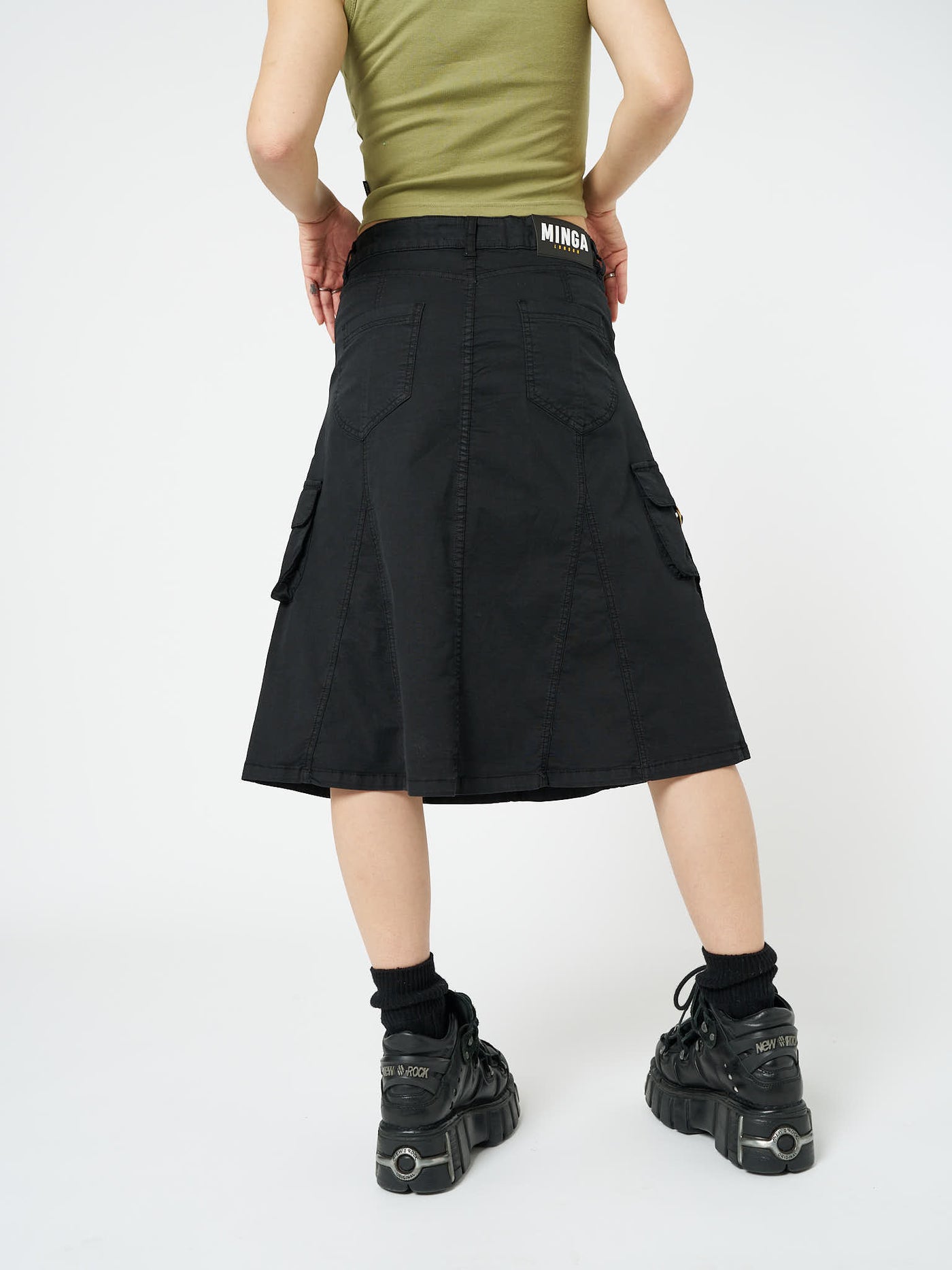 Black cargo midi skirt named Fae by Minga London, showcasing a utilitarian-inspired design for a trendy and versatile addition to your wardrobe.