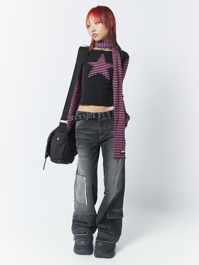 A long sleeve top with pink and black stripes by Minga London. This top features a star patch, adding a unique and eye-catching detail to the overall design.