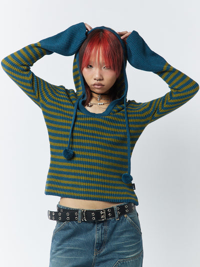 A green and blue striped knitted hoodie named Regina by Minga London. This hoodie combines comfort and style with its striped design, offering a trendy and cozy look.