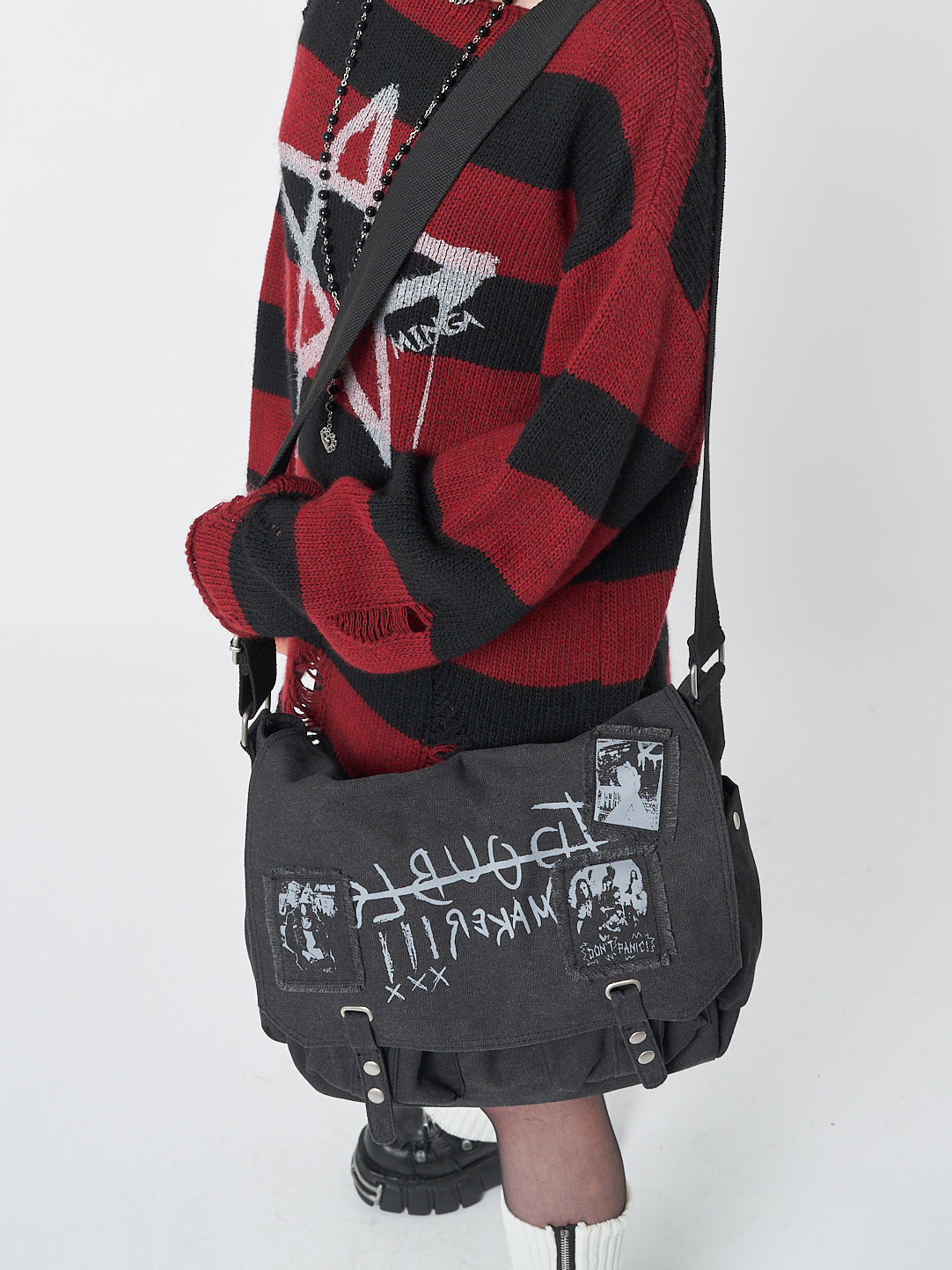 A versatile and edgy messenger bag made from durable black canvas, perfect for the rebellious and adventurous spirit.