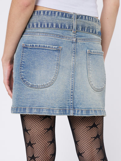 Blue denim mini skirt by Minga London. Low rise waist with a chunky buckle belt. Trendy and versatile for casual looks.