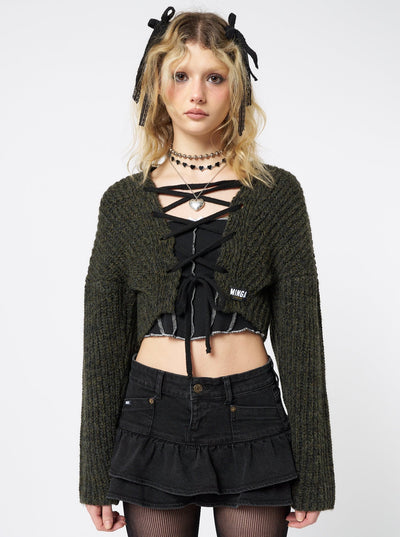  Stay cozy and trendy in this green knitted cardigan featuring a fashionable lace-up detail.