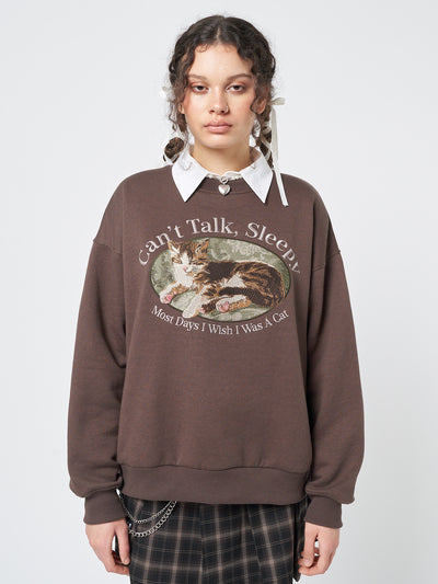 A cozy sweatshirt featuring an adorable "Can't Talk, Sleepy" cat embroidery, perfect for cat enthusiasts.