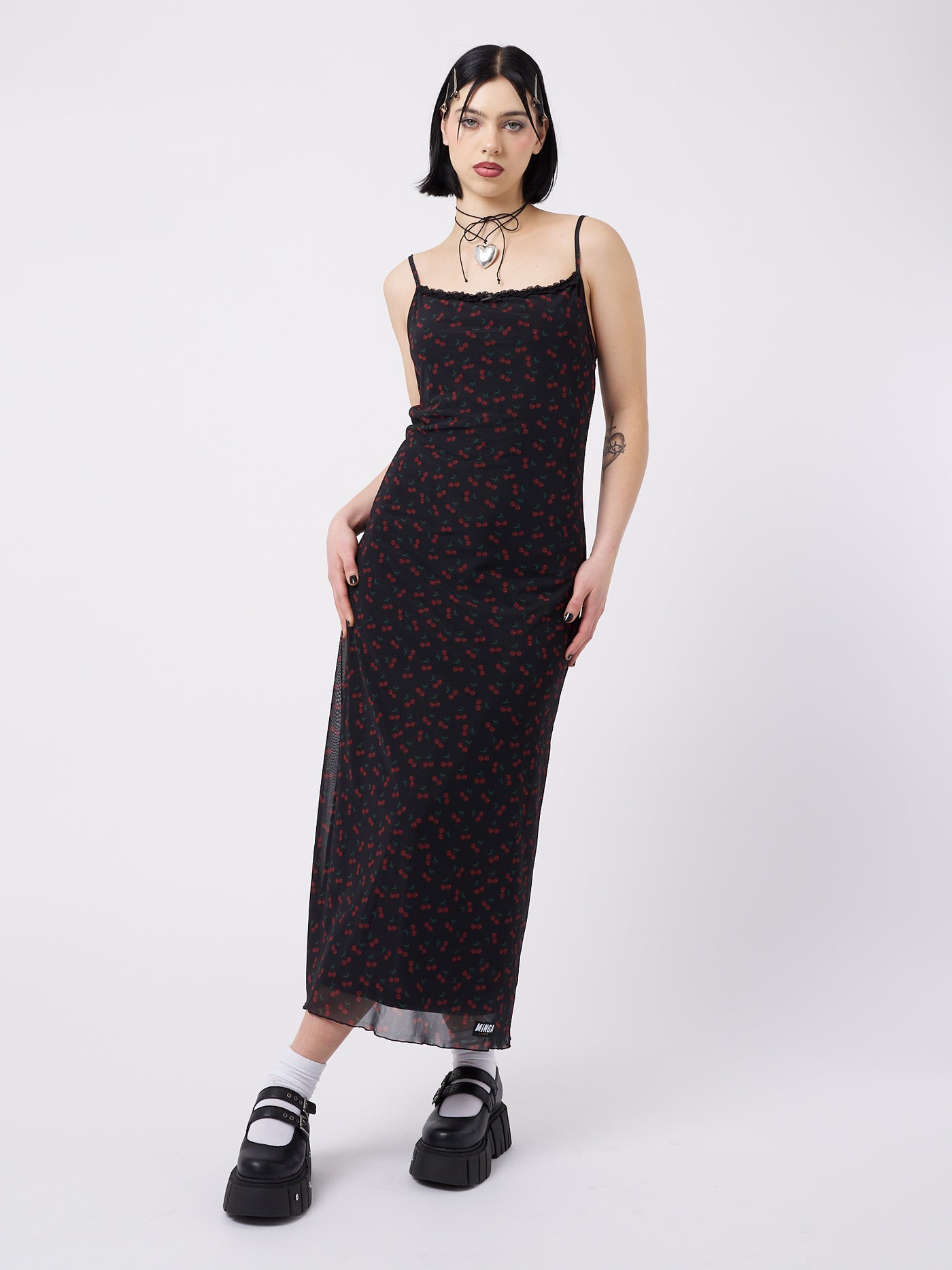 A mesh maxi dress with cherries print in black by Minga London. This skirt features a flirty and airy design, perfect for adding a playful and trendy touch to your outfit.