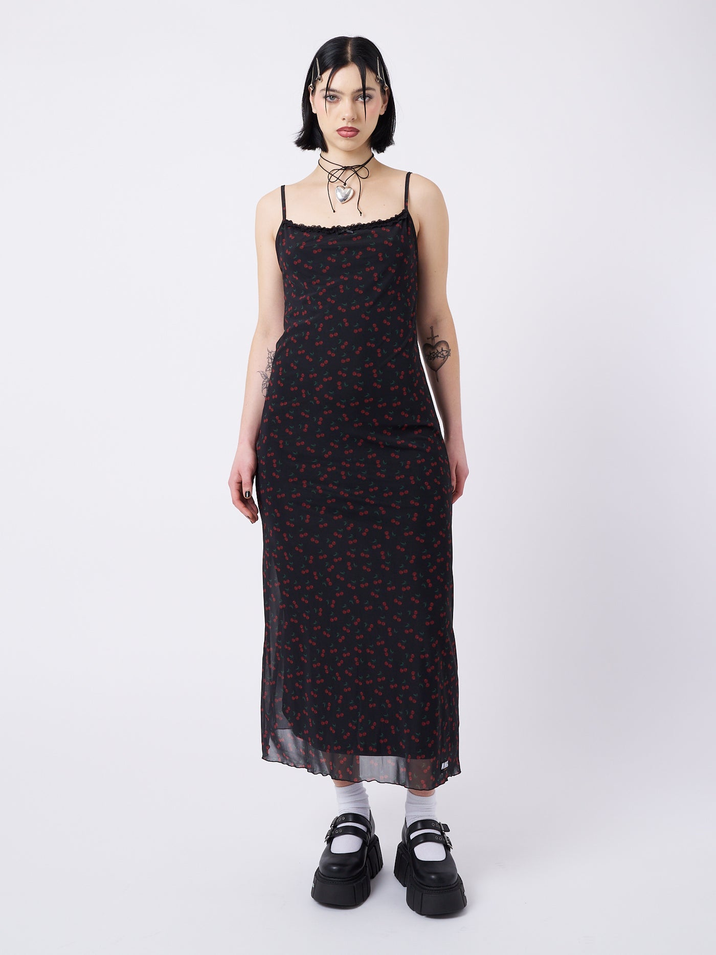 A mesh maxi dress with cherries print in black by Minga London. This skirt features a flirty and airy design, perfect for adding a playful and trendy touch to your outfit.
