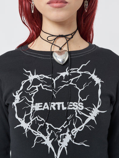 A grunge-inspired silver necklace with a captivating heart pendant, embodying a rebellious and edgy style.