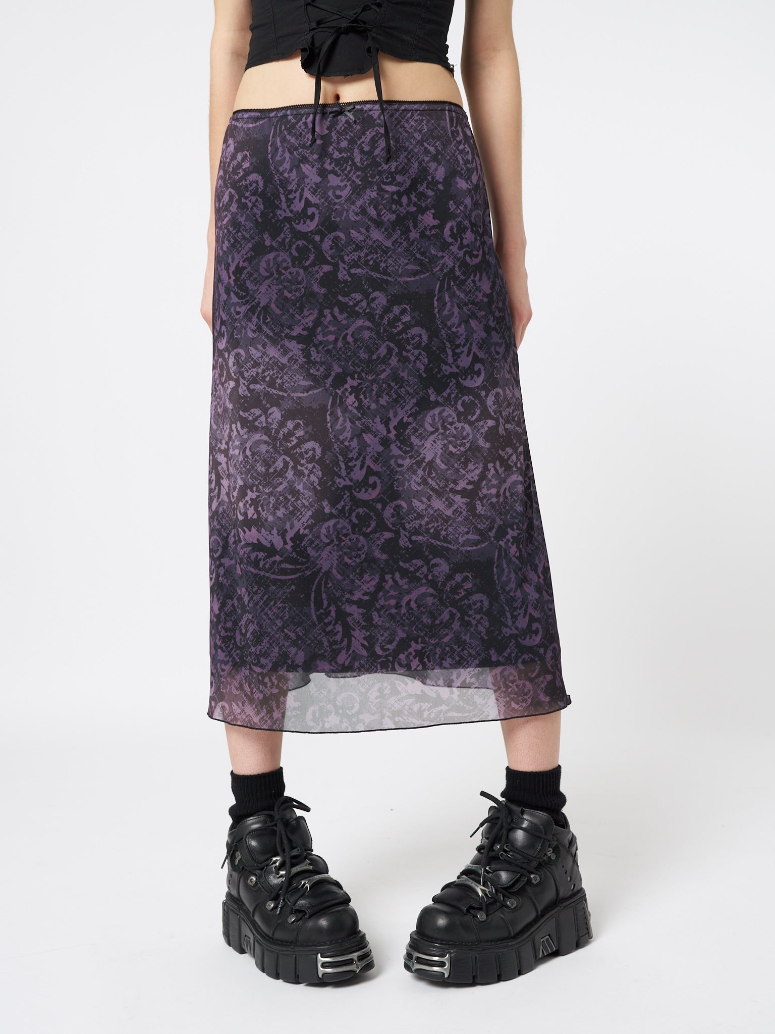 A stunning purple mesh midi skirt adorned with intricate floral prints, capturing the essence of a dark renaissance.