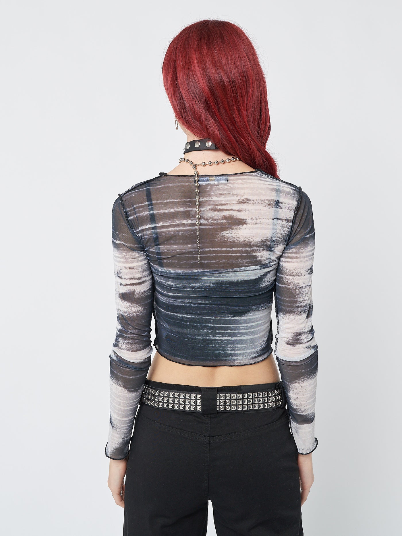 A captivating mesh crop top with a striking design, exuding a sense of boldness and allure.