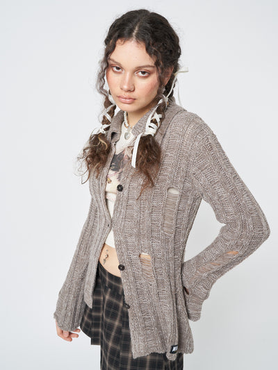 A laid-back and effortlessly stylish sand-colored knit cardigan with a distressed texture for a relaxed vibe.