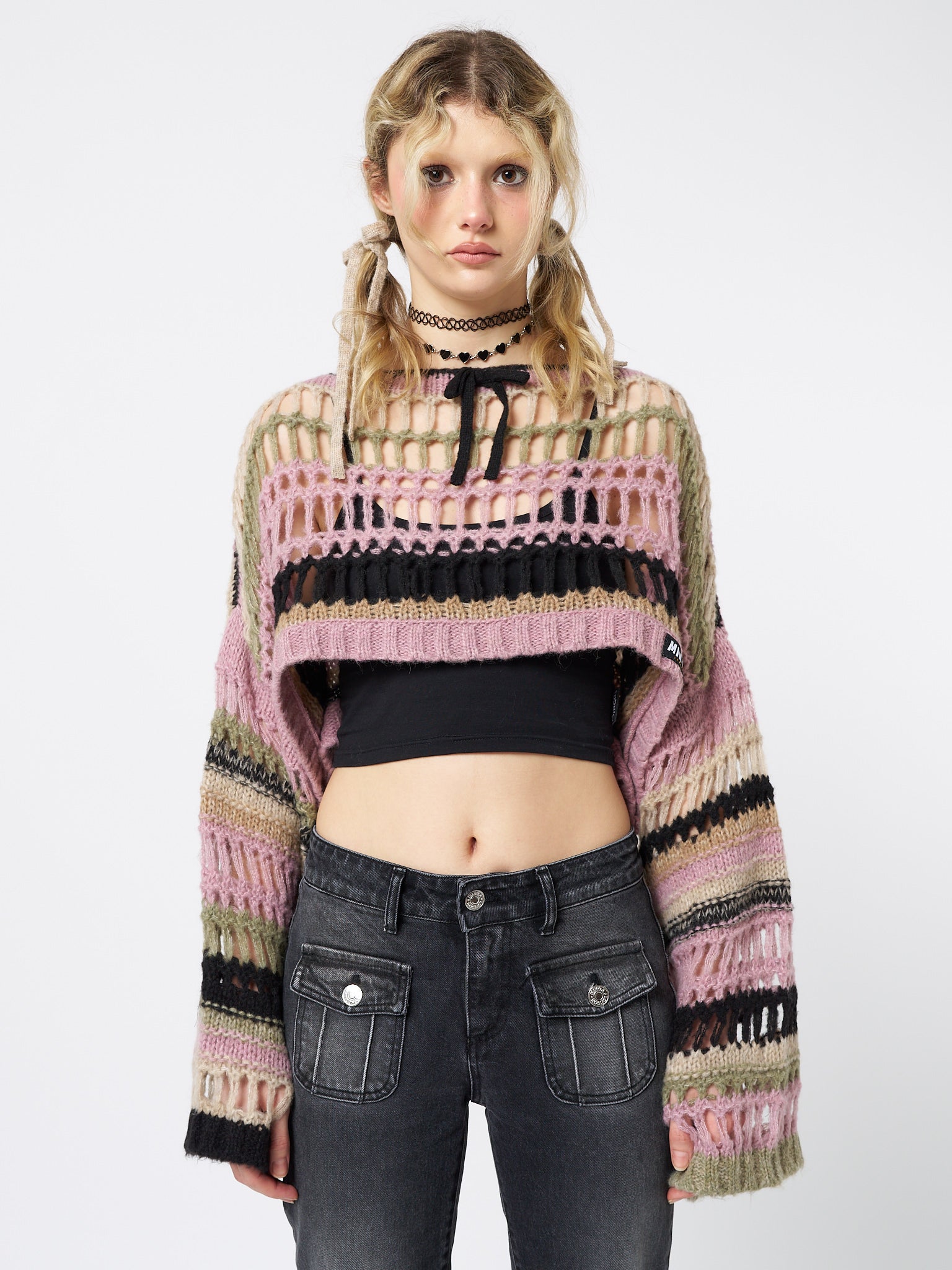 Stay cute and cozy in this pink cropped knit sweater with an edgy twist.