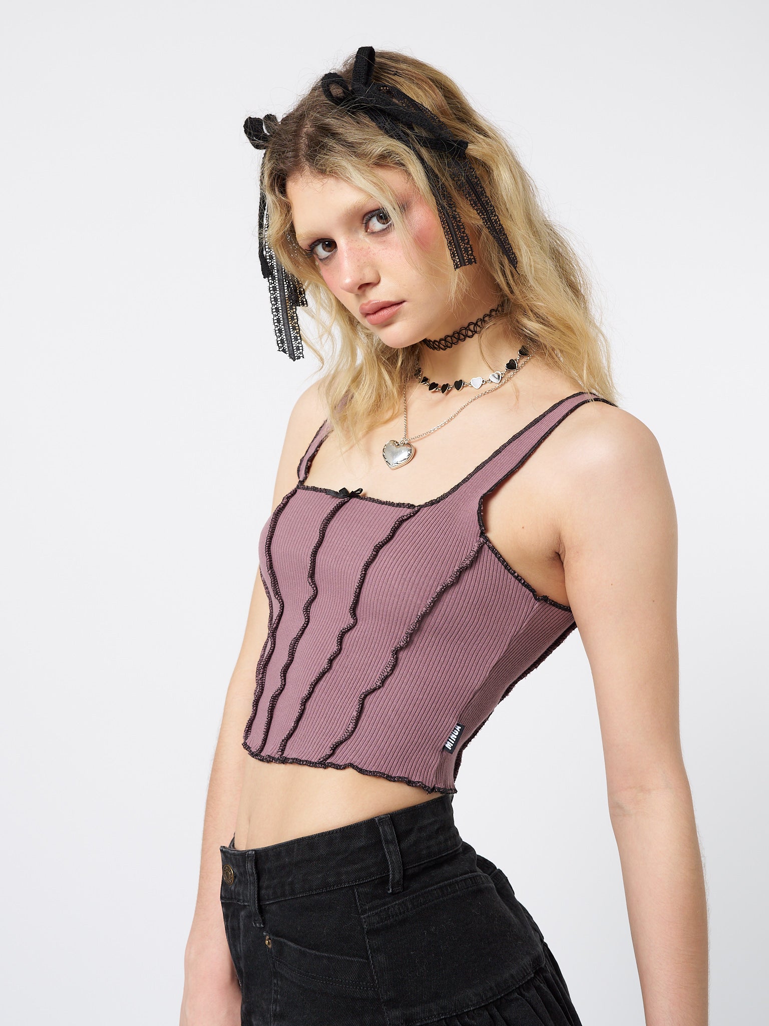 Embrace your dark and feminine side with this edgy pink corset top featuring contrasting stitch details.