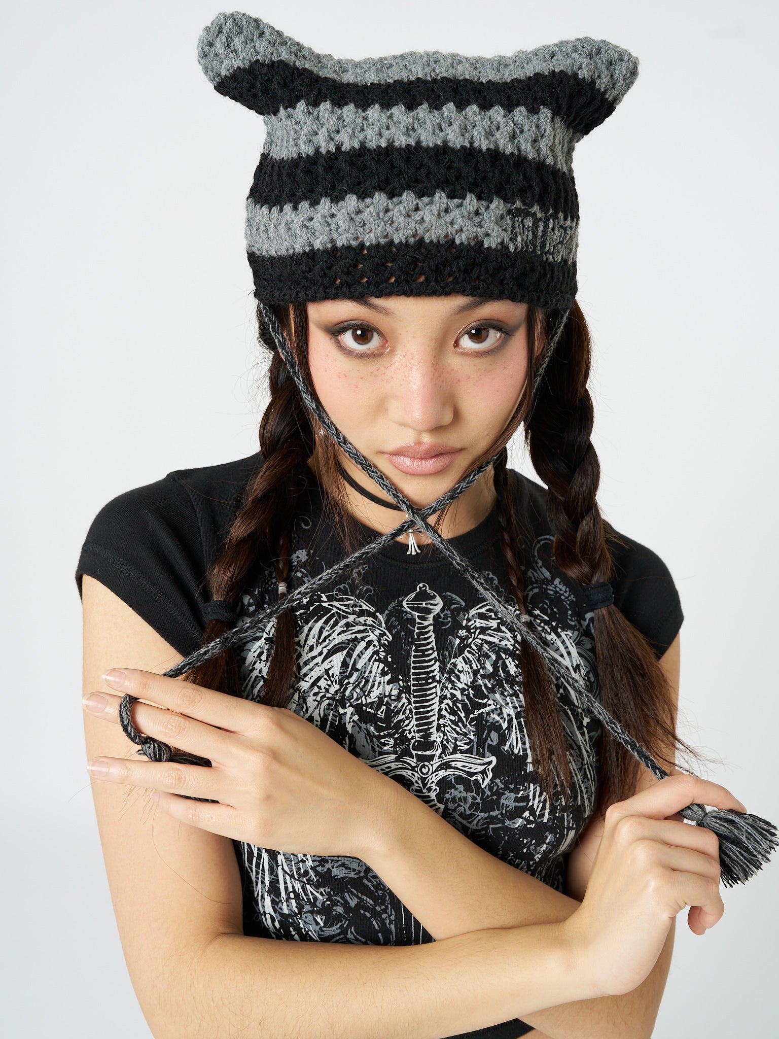 A knit hat named Greta with striped pattern and a tie detail by Minga London. This hat combines style and warmth, making it a trendy and practical accessory for the colder seasons.