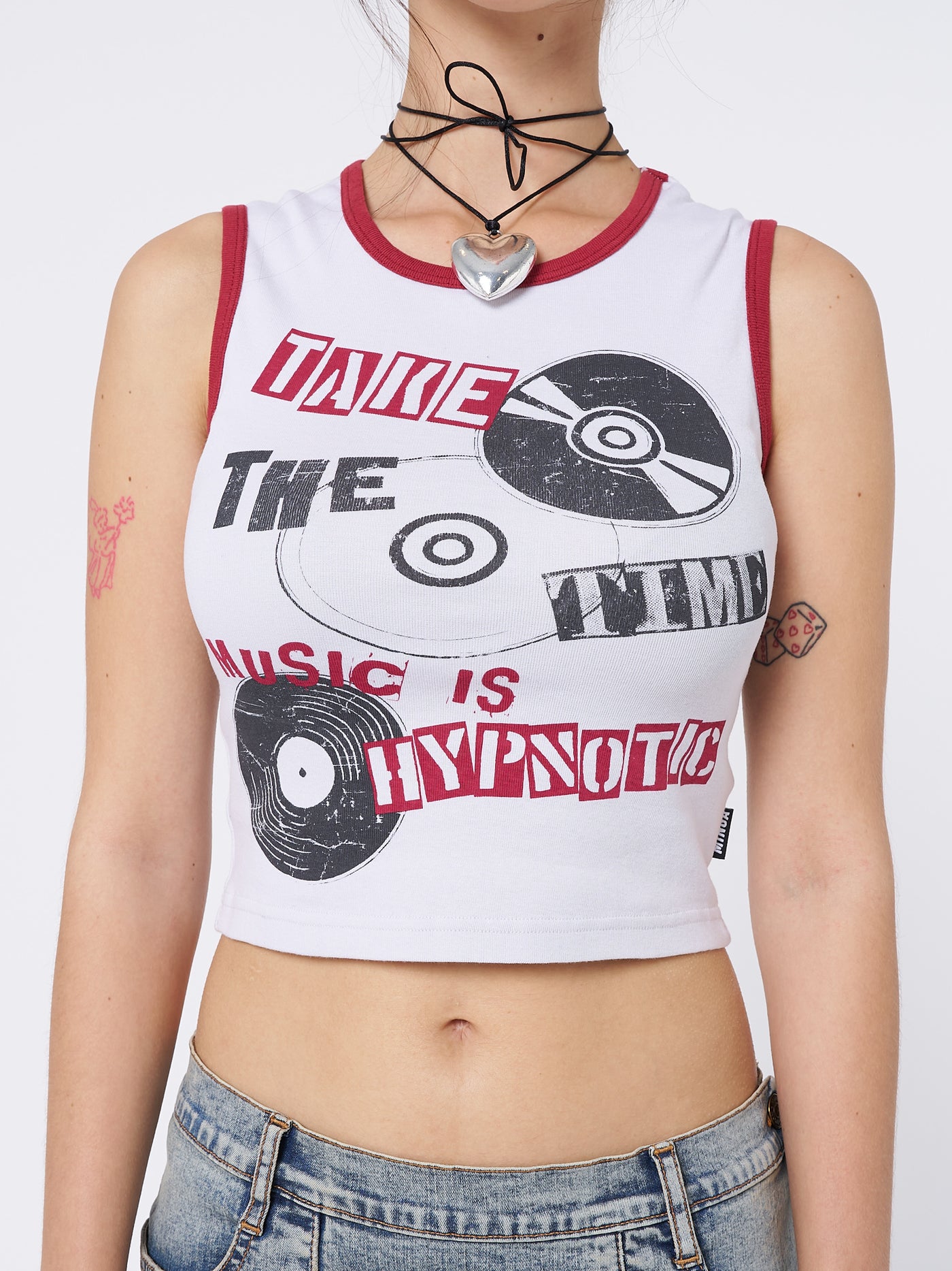 A music-inspired graphic print vest top by Minga London. The top showcases a mesmerizing design with contrast trims in red, adding a vibrant and dynamic touch to your outfit.