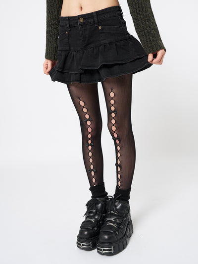 Edgy and retro-inspired, this black denim mini skirt exudes Y2K fashion vibes.
