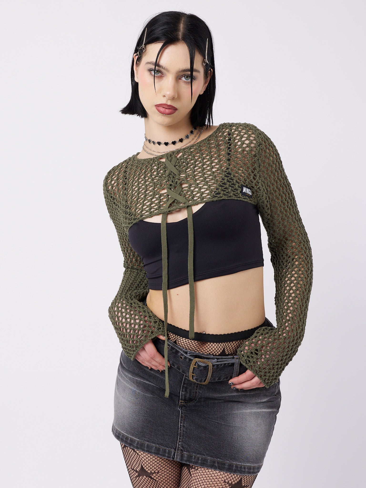 Stylish and versatile green knitted shrug with a trendy lace-up detail. Perfect for adding a touch of contemporary style to any outfit.