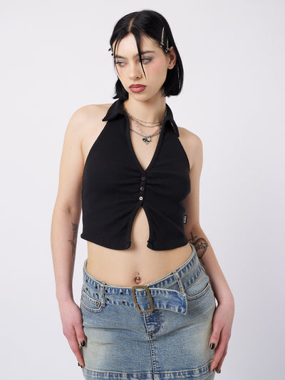 A black halter neck collar top named Raya by Minga London. This top showcases a cool and feminist-inspired design, combining a sleek halter neck and collar detail for a bold and empowering look