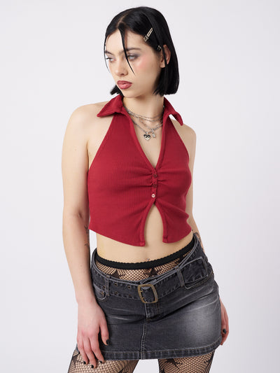 A red halter neck collar top named Raya by Minga London. This top features a bold and empowering design with an open back, adding a touch of allure and femininity to your outfit.