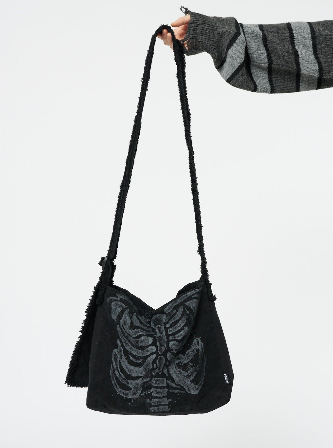 A shoulder strap bag with an X-ray skeleton design by Minga London. This unique bag features a striking and edgy print that adds a touch of alternative style to your outfit, making a bold statement wherever you go.
