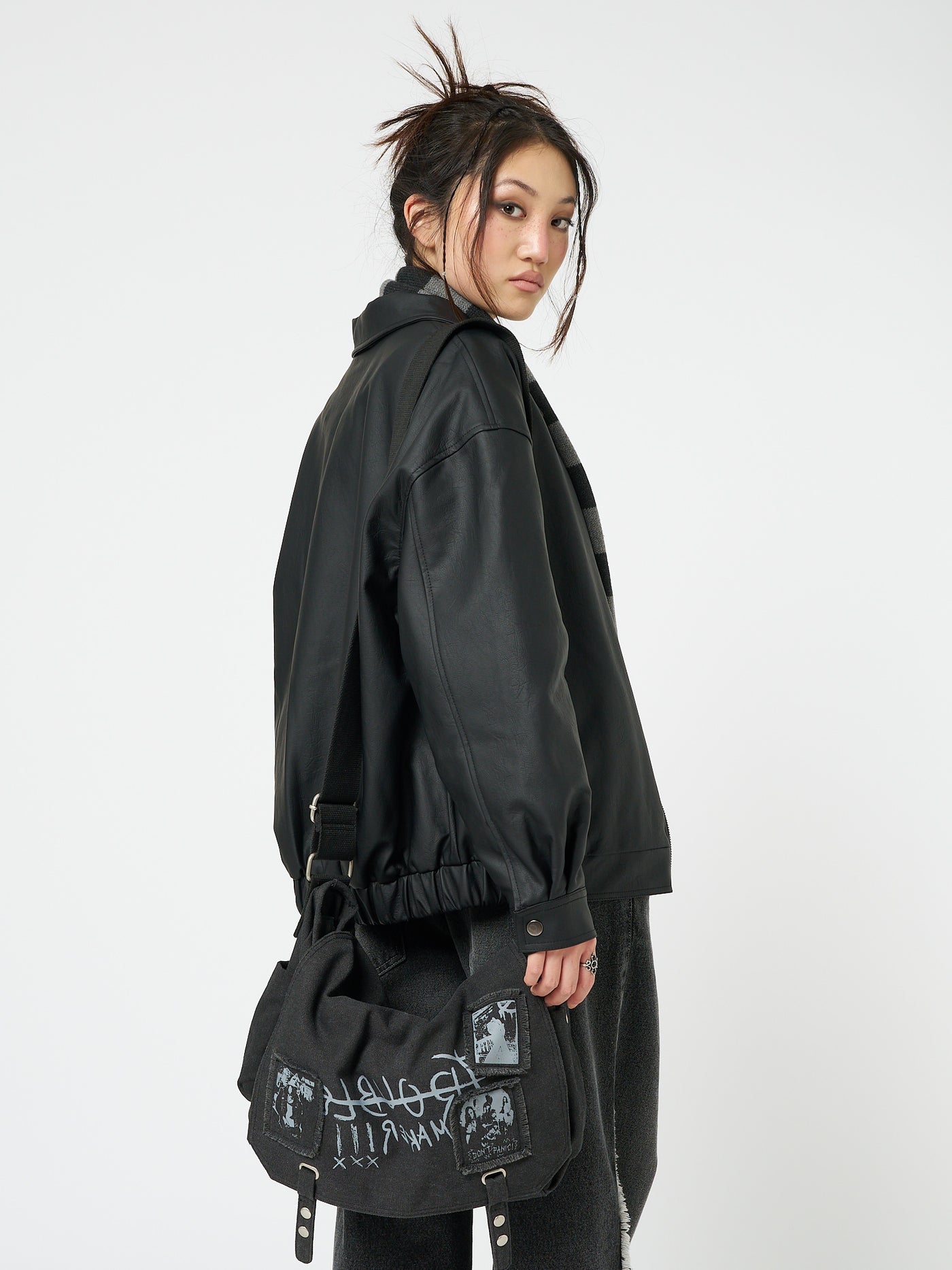 A black vegan leather bomber jacket named Olivia by Minga London. This jacket exudes a cool and edgy vibe with its bomber silhouette and sleek black vegan leather material, making it a versatile and stylish addition to your wardrobe.